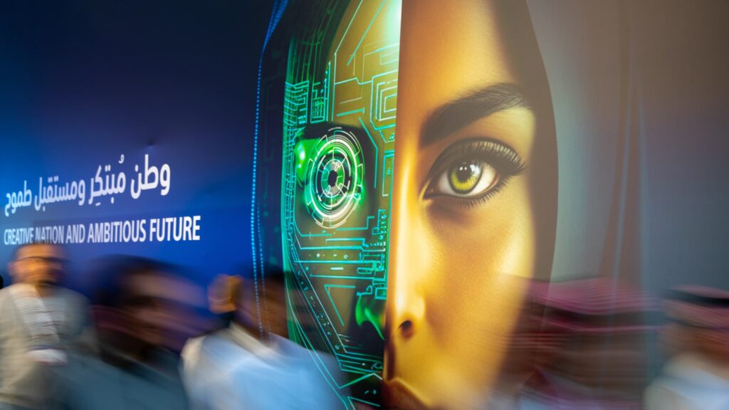 A crowd passing by a huge advertisement displayed on a wall.